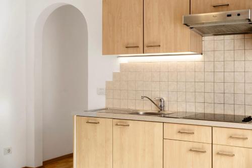 a kitchen with wooden cabinets and a sink at Hatzlhof Appartements in Vipiteno