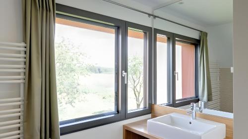 a bathroom with a sink and a large window at Ferienhaus Wreechen 25, Haus 1 in Putbus