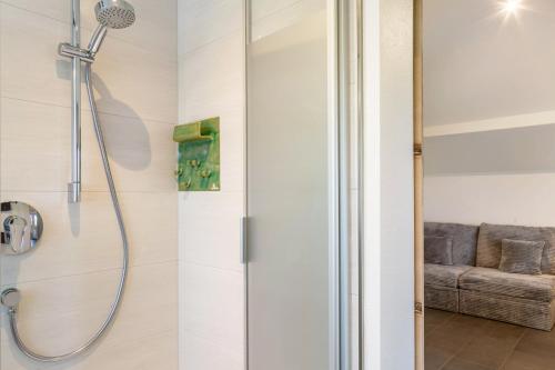 a shower stall in a bathroom with a couch at Pur Wohnen - Wohnung Fernsicht in Bad Griesbach