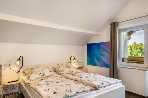 a bedroom with a bed and a window at Pur Wohnen - Wohnung Fernsicht in Bad Griesbach