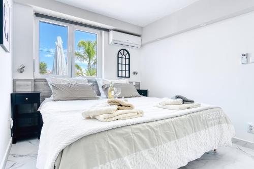 a white bedroom with a large bed with towels on it at Park Carpe Diem in Busot