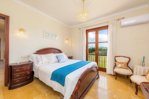 ein Schlafzimmer mit einem Bett, einem Stuhl und einem Fenster in der Unterkunft Finca Llum in Islas Baleares