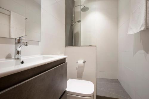 a white bathroom with a toilet and a sink at Falco 3 in Corralejo