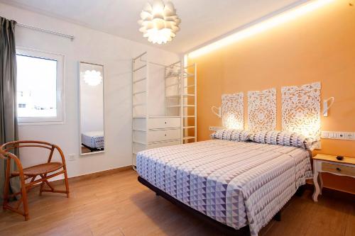 a bedroom with a bed and a chair and a window at Falco 3 in Corralejo