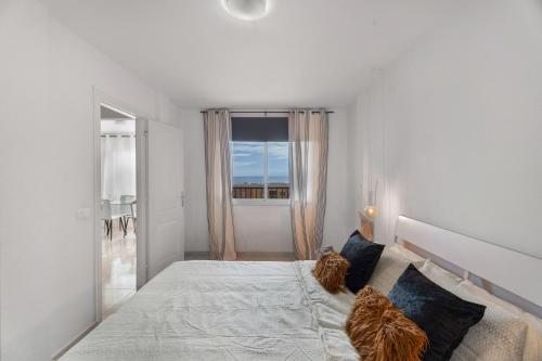 a bedroom with a large bed with two cats sitting on it at Apartamento Erma Candelaria in Candelaria