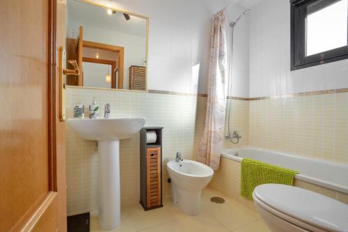a bathroom with a sink and a toilet and a tub at Vanilla Ocean Chalet in Majanicho