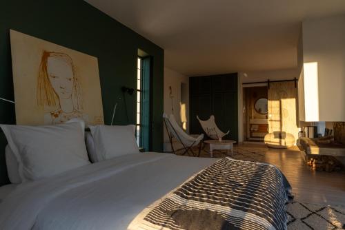 a bedroom with a bed with a painting on the wall at Villa Celeste-Essaouira, piscine chauffée, vue sur la campagne in Essaouira