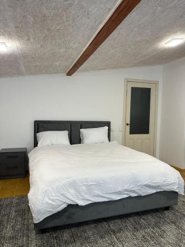 a bedroom with a large bed with white sheets at HomeRent Bucuresti Studio in Chişinău