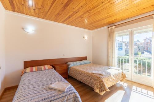 a bedroom with two beds and a window at Las Gargantas de Gredos in Burgohondo