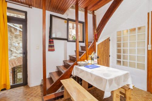 a dining room with a table and some stairs at Au Petit Paris, Centre de Céret in Céret