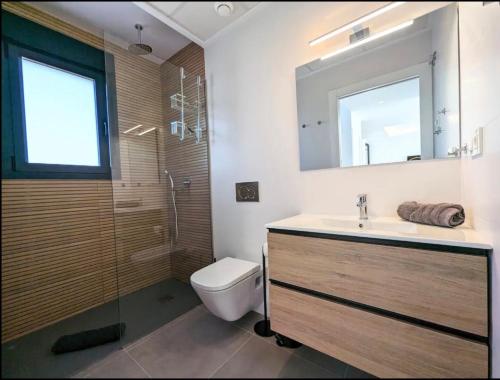 a bathroom with a sink and a toilet and a mirror at R-53 Corner Villa with private pool in Los Montesinos