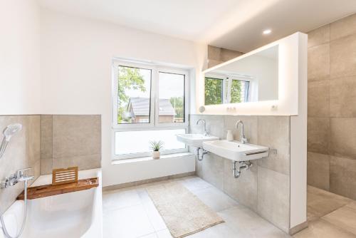 a bathroom with a sink and a shower and a window at Das Strandhaus 2 in Lembruch