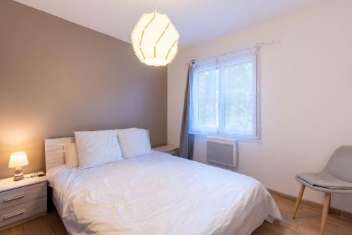 a bedroom with a white bed and a window at Chalets De L'arriutort 1 - Laruns in Laruns