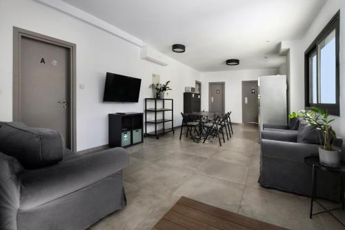a living room with two couches and a dining room at Urban Habitat Capsule Beds in Nicosia