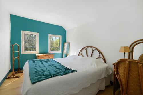 a bedroom with a bed with a blue wall at Gite De Marlas in Rieucros