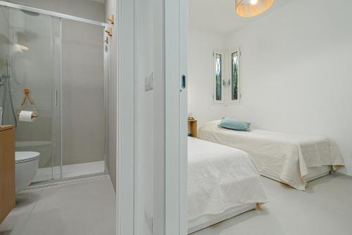 a white bathroom with a bed and a shower at Casa Dina - by And Service in Golfo Aranci