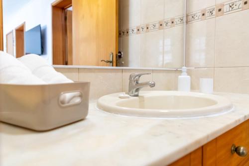 a bathroom with a sink and a mirror at Central Square in Povoação
