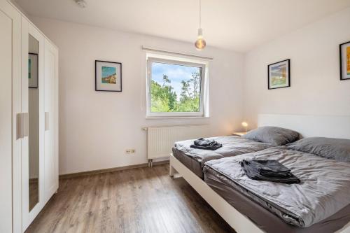 a bedroom with two beds and a window at Sonne, Wind und Wetter in Wurster Nordseeküste