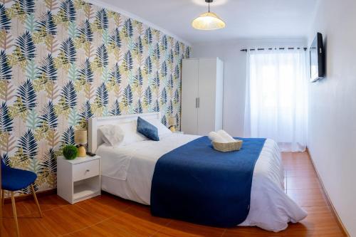 a bedroom with a bed with a blue blanket at Central Square in Povoação