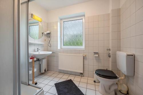 a bathroom with a toilet and a sink at Sonne, Wind und Wetter in Wurster Nordseeküste