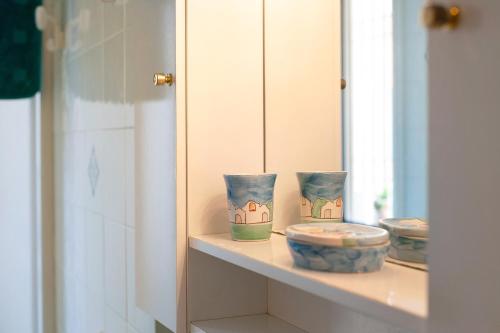 a shelf with three bowls on it in a bathroom at Trilocale Mazzini con 2 balconi in Varazze