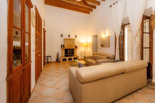a living room with a couch and a fireplace at Ca la Senyora dels Arbres in Artá