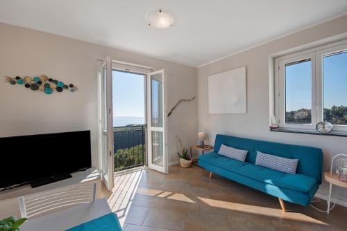 a living room with a blue couch and large windows at Casa Marincanto in Varazze