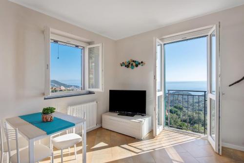 a living room with a table and a tv and windows at Casa Marincanto in Varazze