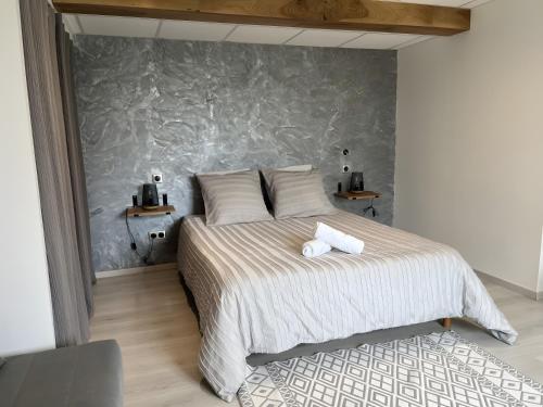 a bedroom with a bed with two towels on it at Appartement Gorges du Tarn in Mostuéjouls