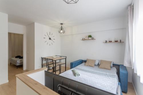 a living room with a bed and a clock on the wall at Playa De Las Américas - Oceanfront in Costa de Adeje