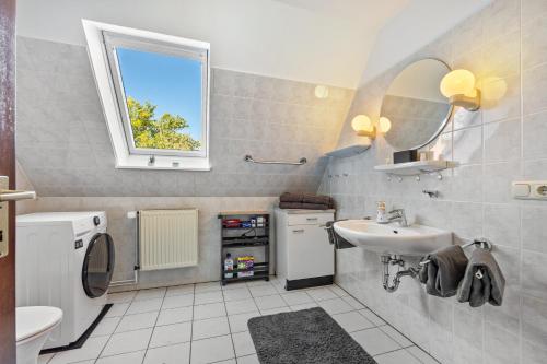 a bathroom with a sink and a washing machine at Gästehaus Oehm in Faßberg