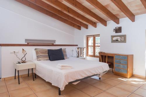 a bedroom with a large bed and a wooden ceiling at Sa Fusteria in Sóller