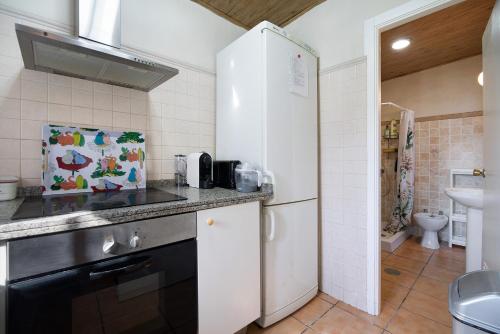 a kitchen with a white refrigerator and a sink at Beautiful Traditional House in Chipiona