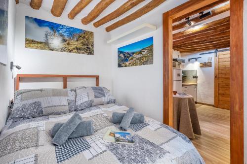 a bedroom with a bed with gray pillows at Apartamentos cuna del Genil in Güéjar-Sierra