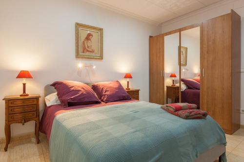 a bedroom with a large bed and a mirror at Amelie Apartment in Canet de Mar