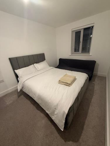 a bedroom with a large bed with white sheets at Dzingai Home in Newport