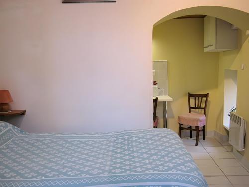 a bedroom with a bed and a table and a chair at Studio chambre d'hôte in Panazol