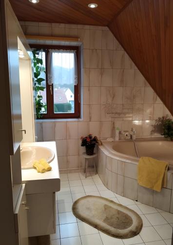a bathroom with a tub and a sink and a bath tub at Chambres D'hôtes - Suite Pampas in Geiswiller