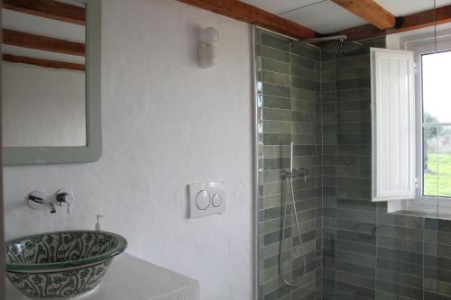 ein Badezimmer mit Waschbecken und Glasdusche in der Unterkunft Monte Barriga in Beja