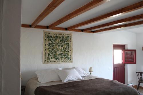 ein Schlafzimmer mit einem Bett und einem Gemälde an der Wand in der Unterkunft Monte Barriga in Beja