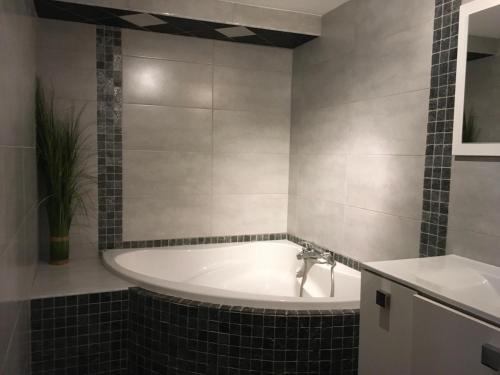 a bathroom with a tub and a sink at Chaleureuse Maison de Montagne in Garin