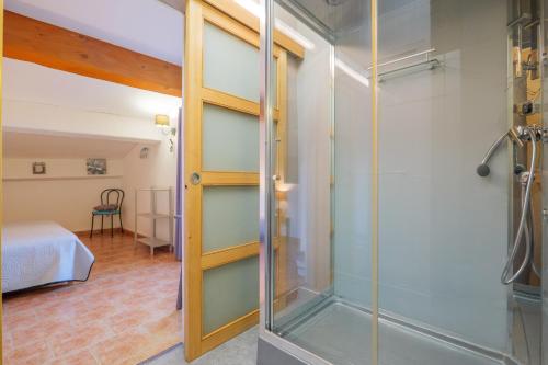 a glass shower in a room with a bedroom at Perles De Aime in Laurac-en-Vivarais