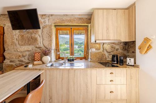 a kitchen with a sink and a window at Estúdio à Beira da Água no Gerês in Geres