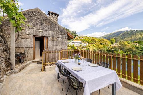 a table and chairs on the patio of a house at Estúdio à Beira da Água no Gerês in Geres