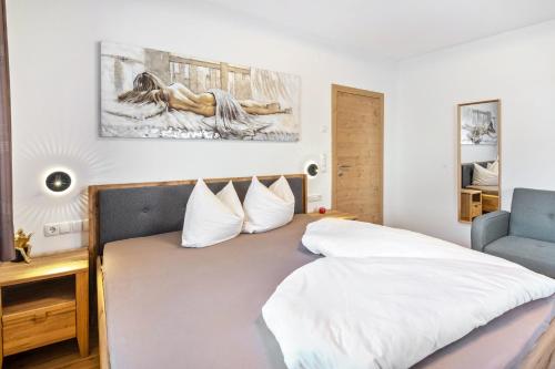 a bedroom with a bed with white sheets and a chair at Pixnerhof - Ferienwohnung Golden in Kastelbell-Tschars