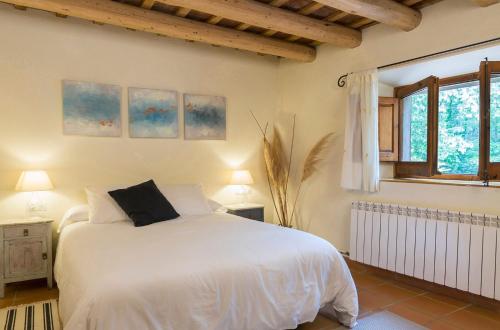 a bedroom with a white bed and a window at Can Bonet - la Volta in Sant Martí Vell