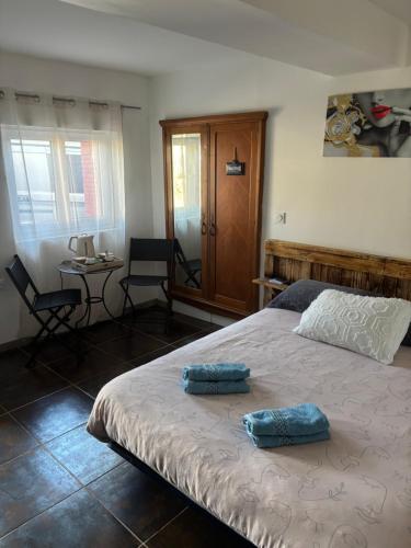 a bedroom with a bed with two blue pillows on it at Propriétaire privé in Carcassonne