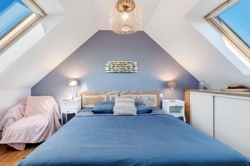 a bedroom with a blue bed in a attic at Ker Helo-ana in Brignogan-Plage