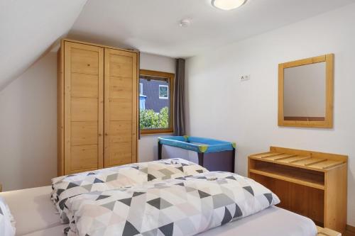 a bedroom with a bed and a mirror and a dresser at Ferienhaus Hensler in Hinterzarten