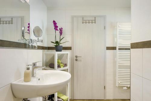 a white bathroom with a sink and a mirror at Ferienhaus Hensler in Hinterzarten